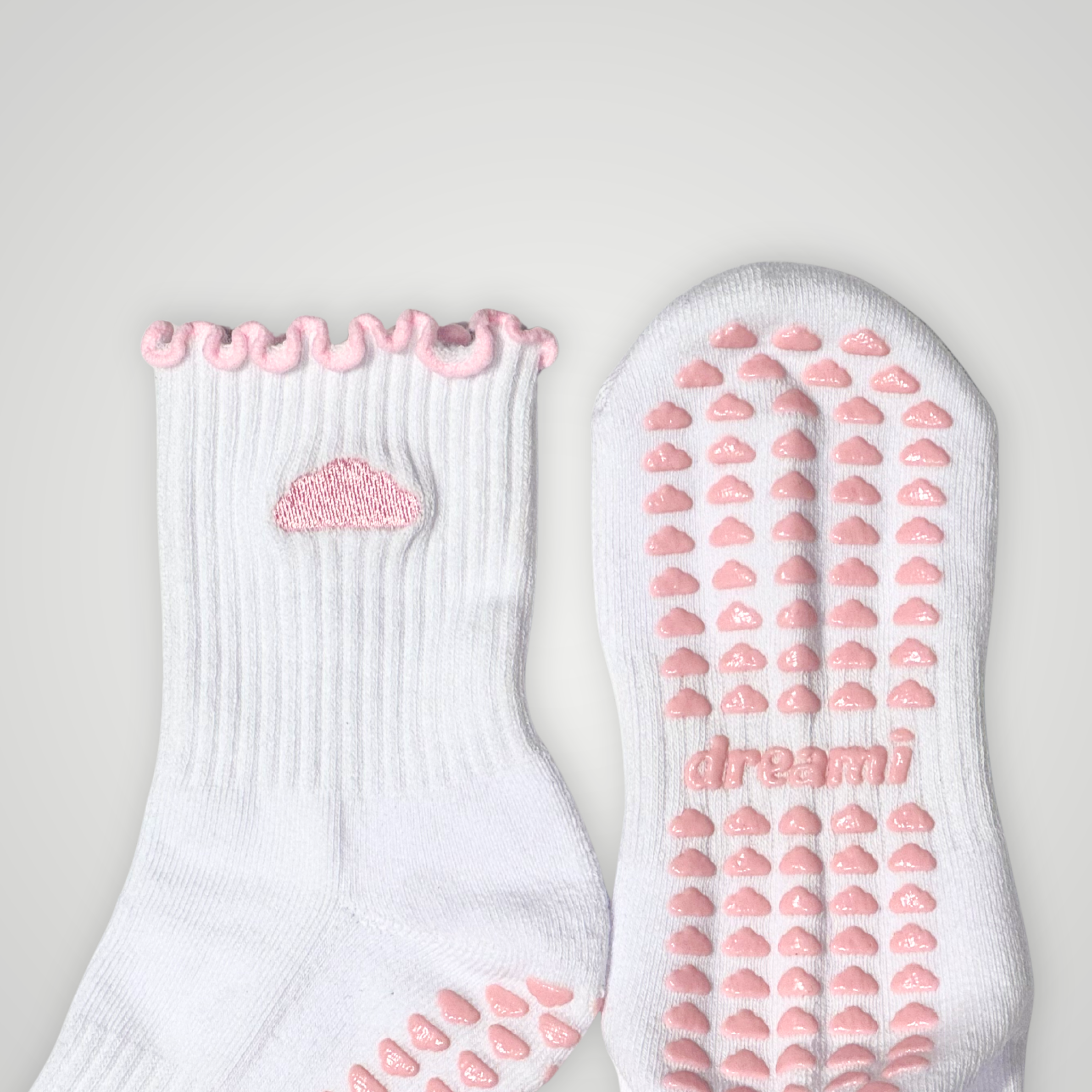 Close up of white socks with pink cloud design and grips