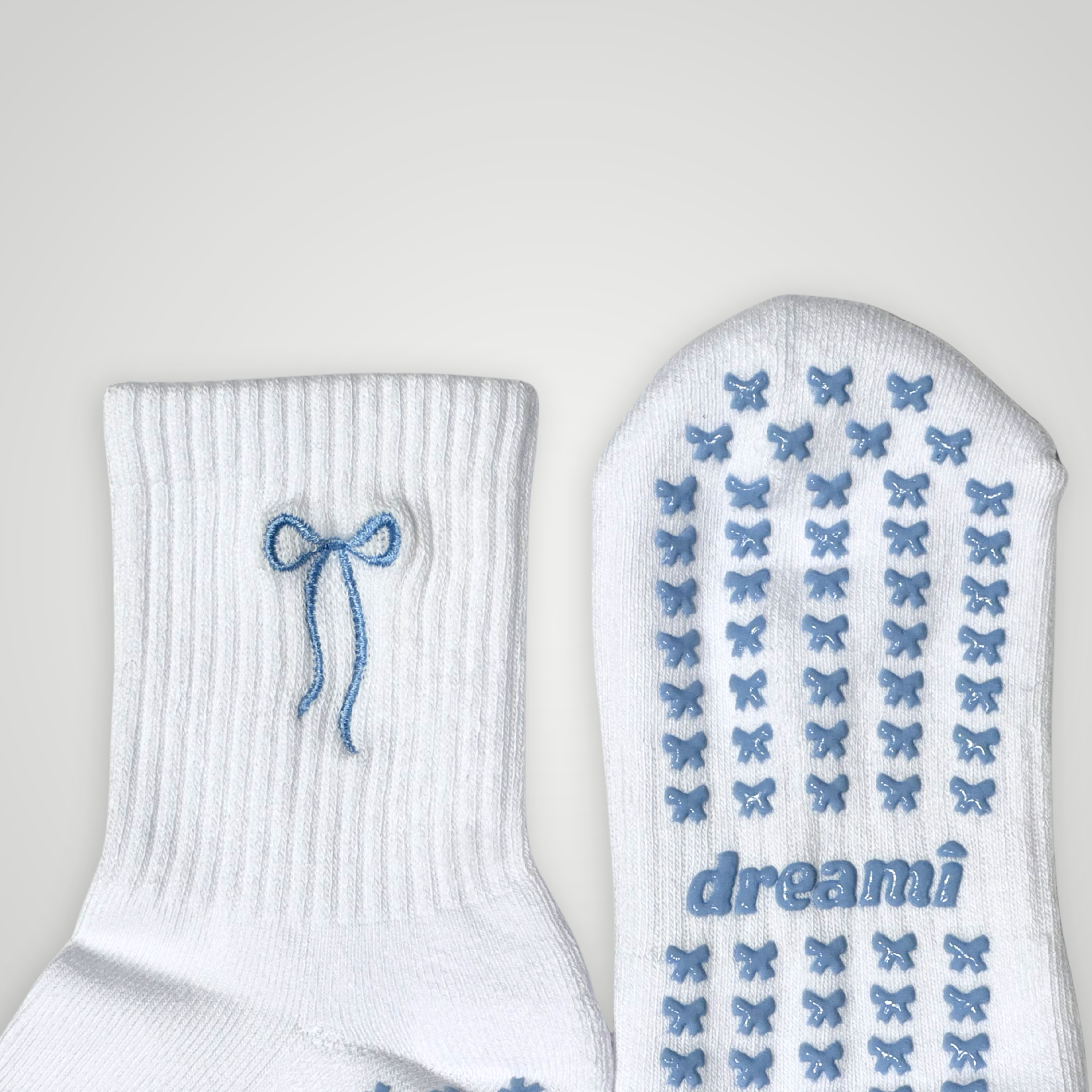 Close up of white socks with blue bow design and bow grips