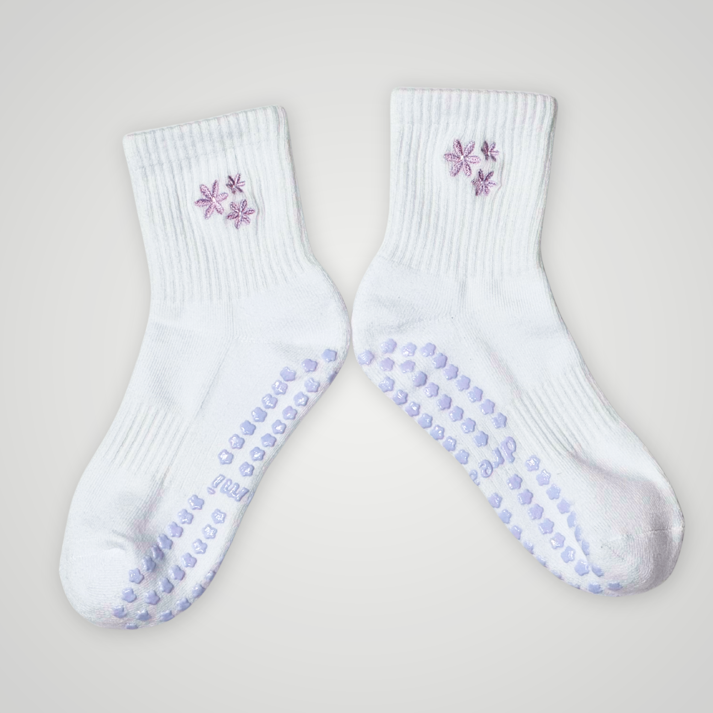 White socks with purple flower design and grips